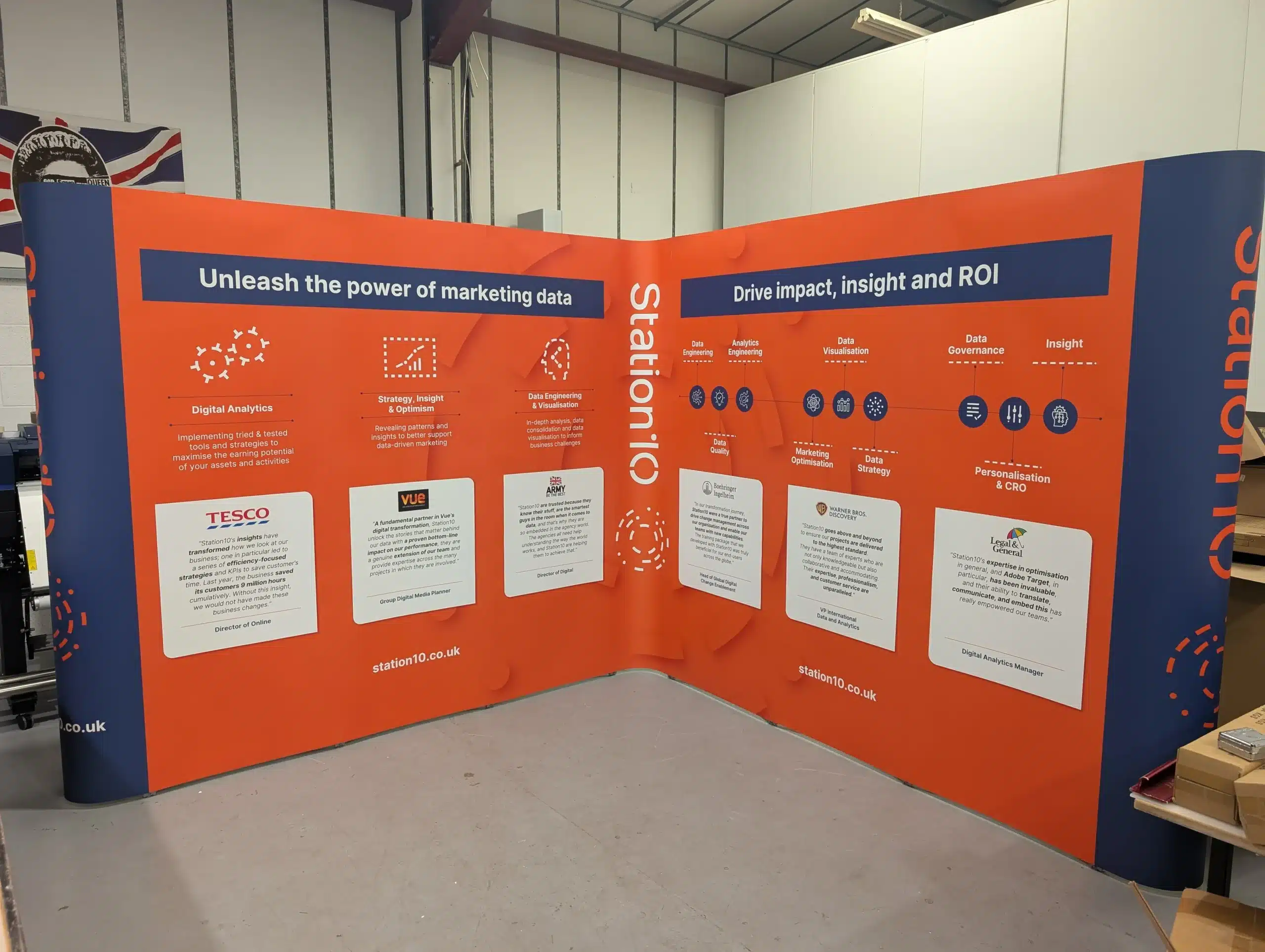 large l - shaped popup display stand at 3m x 3m in size with large impactful orange graphics