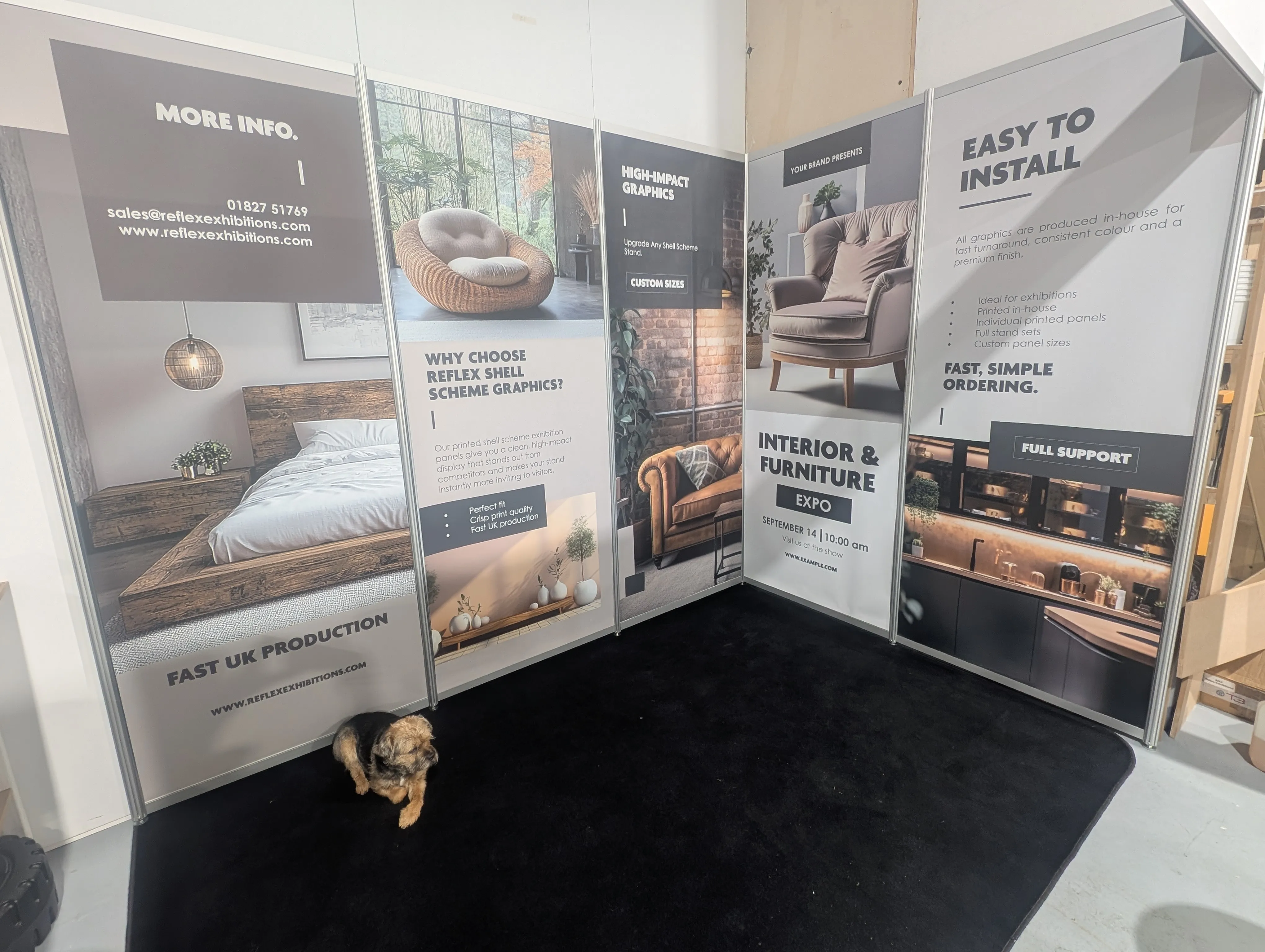 Custom shell scheme panels for exhibition branding, showcasing various interior designs and furniture, featuring promotional text about installation, support, and contact details, with a small dog on a black carpet.